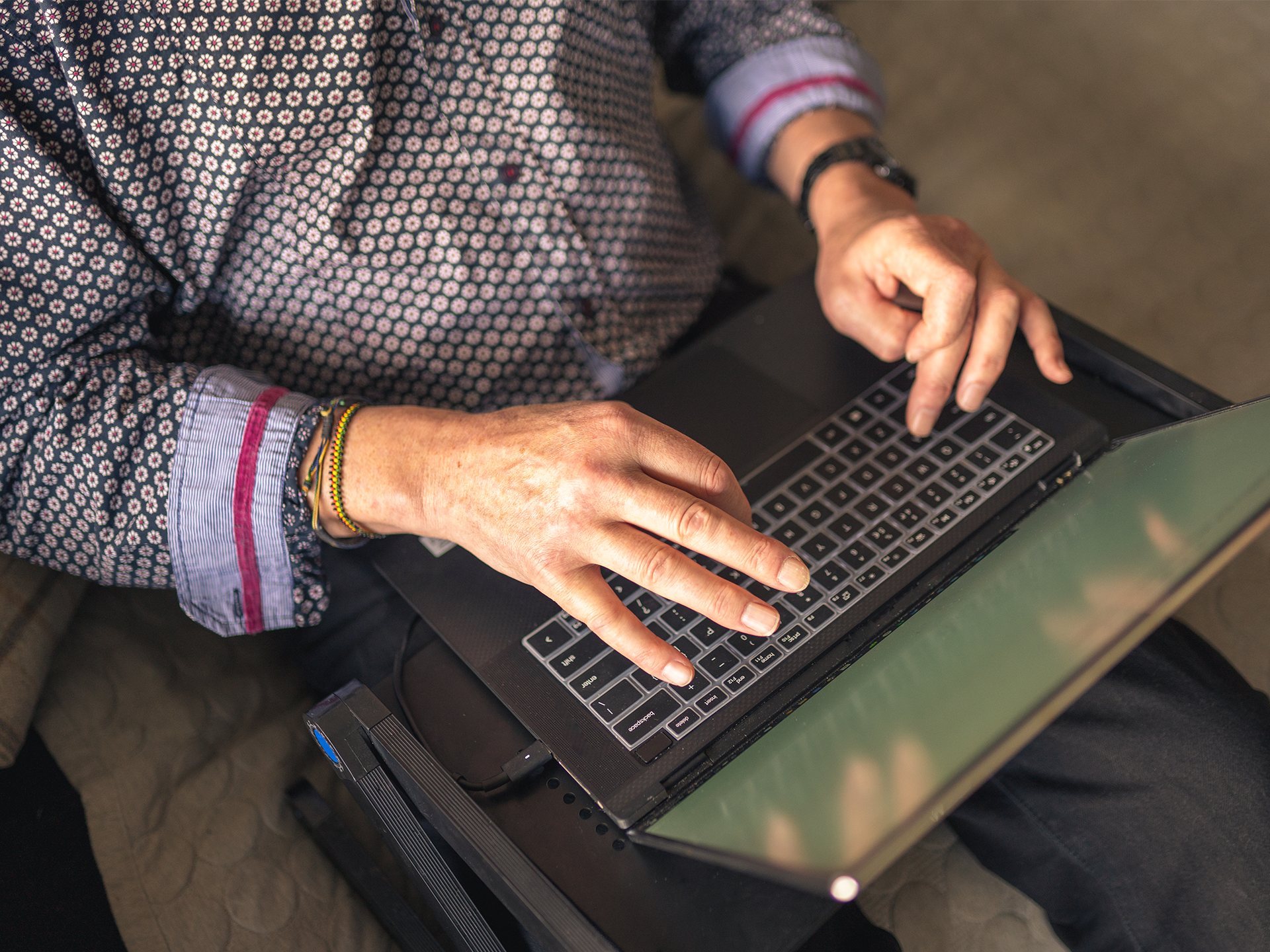 Hands typing on laptop