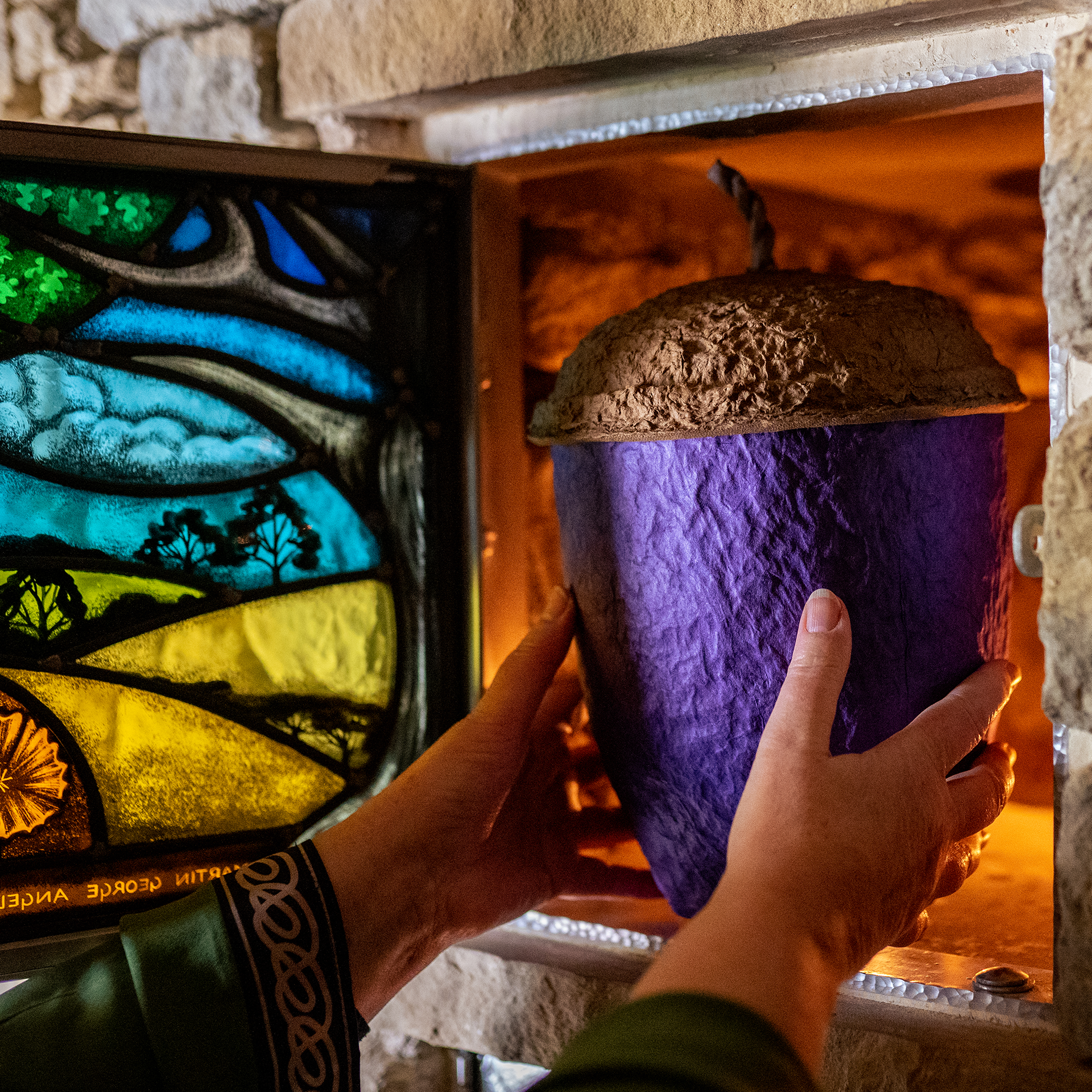 Hands placing acorn urn in chamber