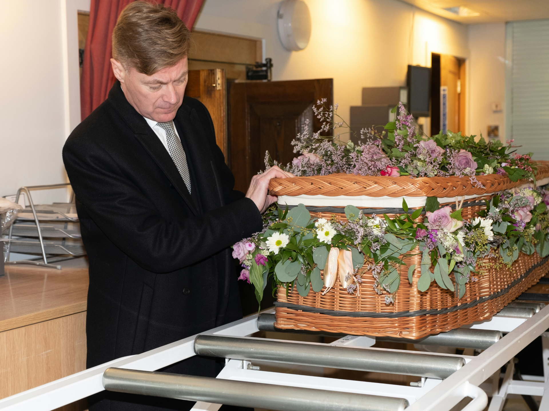 Coffin with crematorium assistant