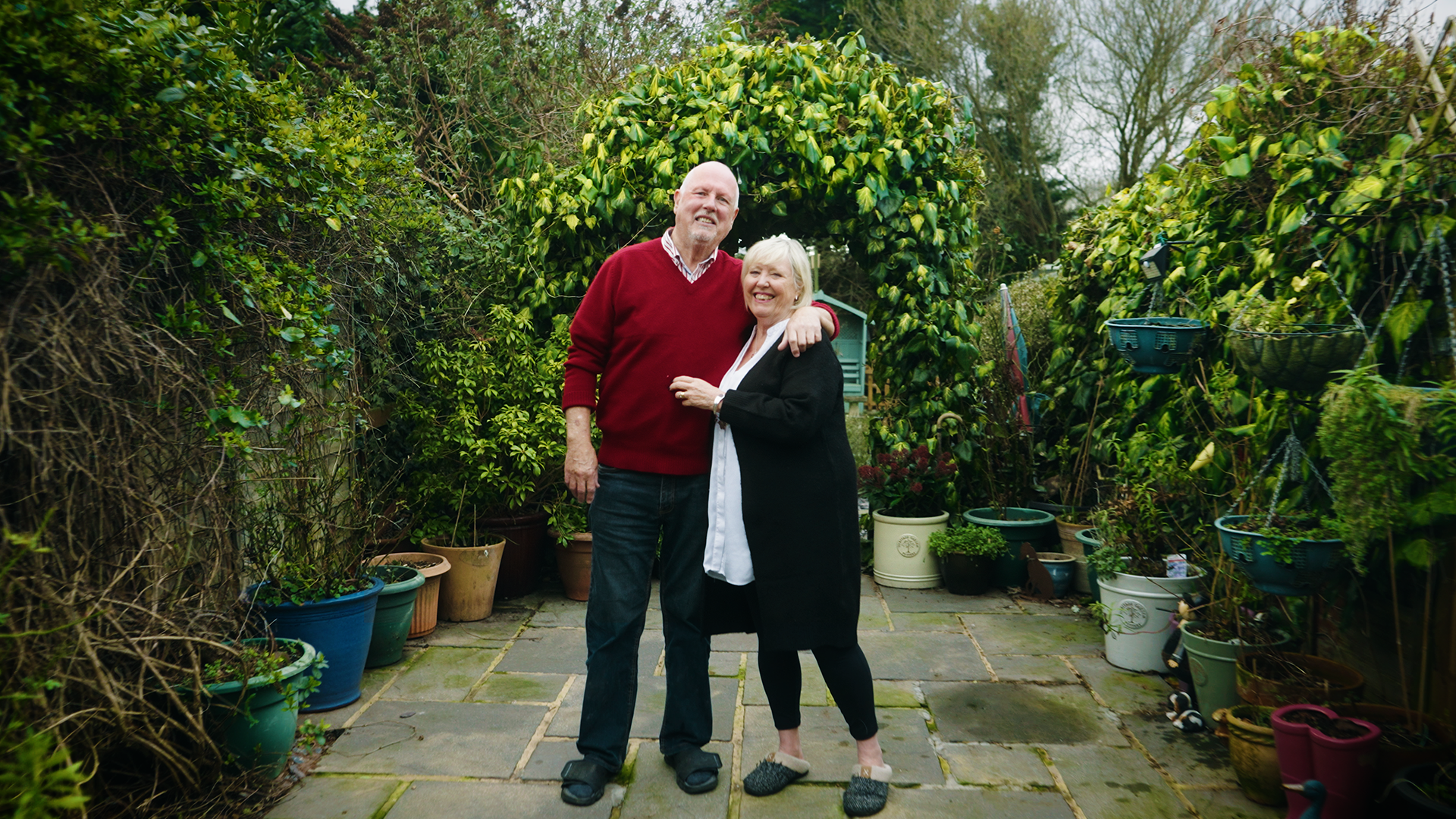 Man and woman standing in garden smiling