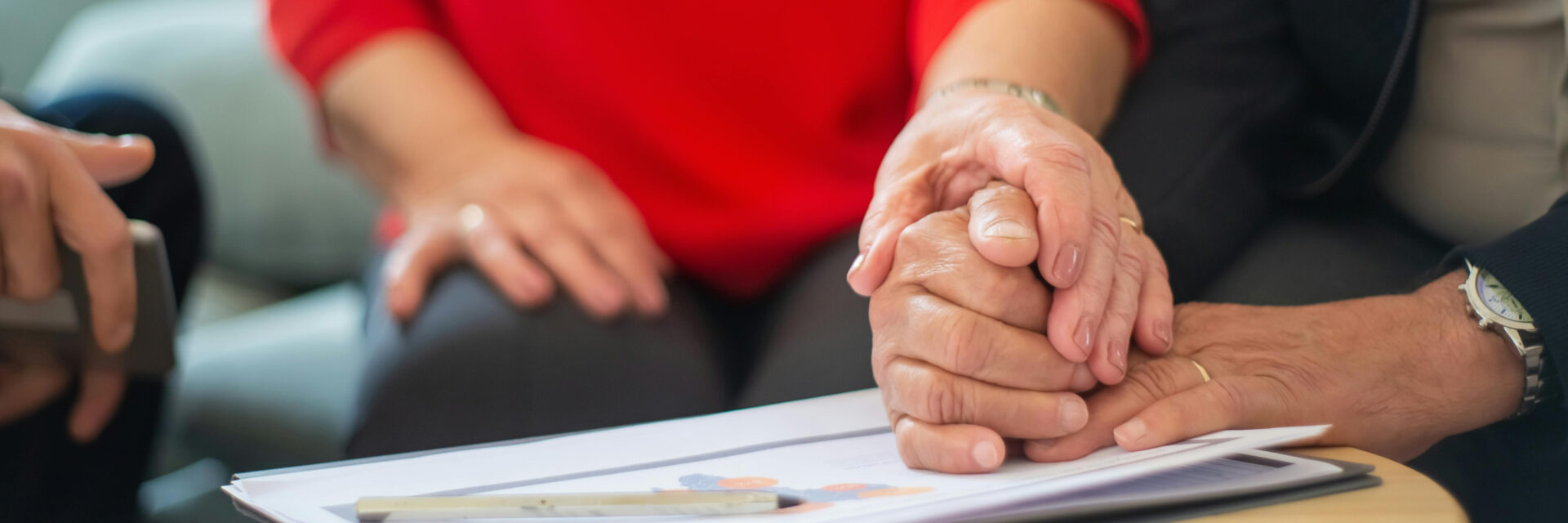 People holding hands in a meeting