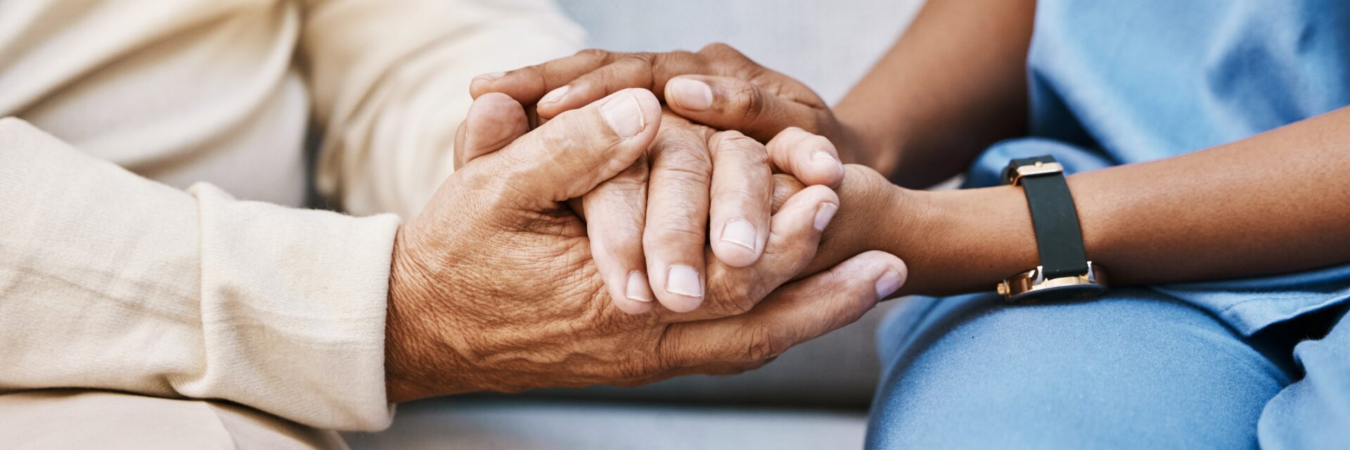 Care home staff holding resident hand