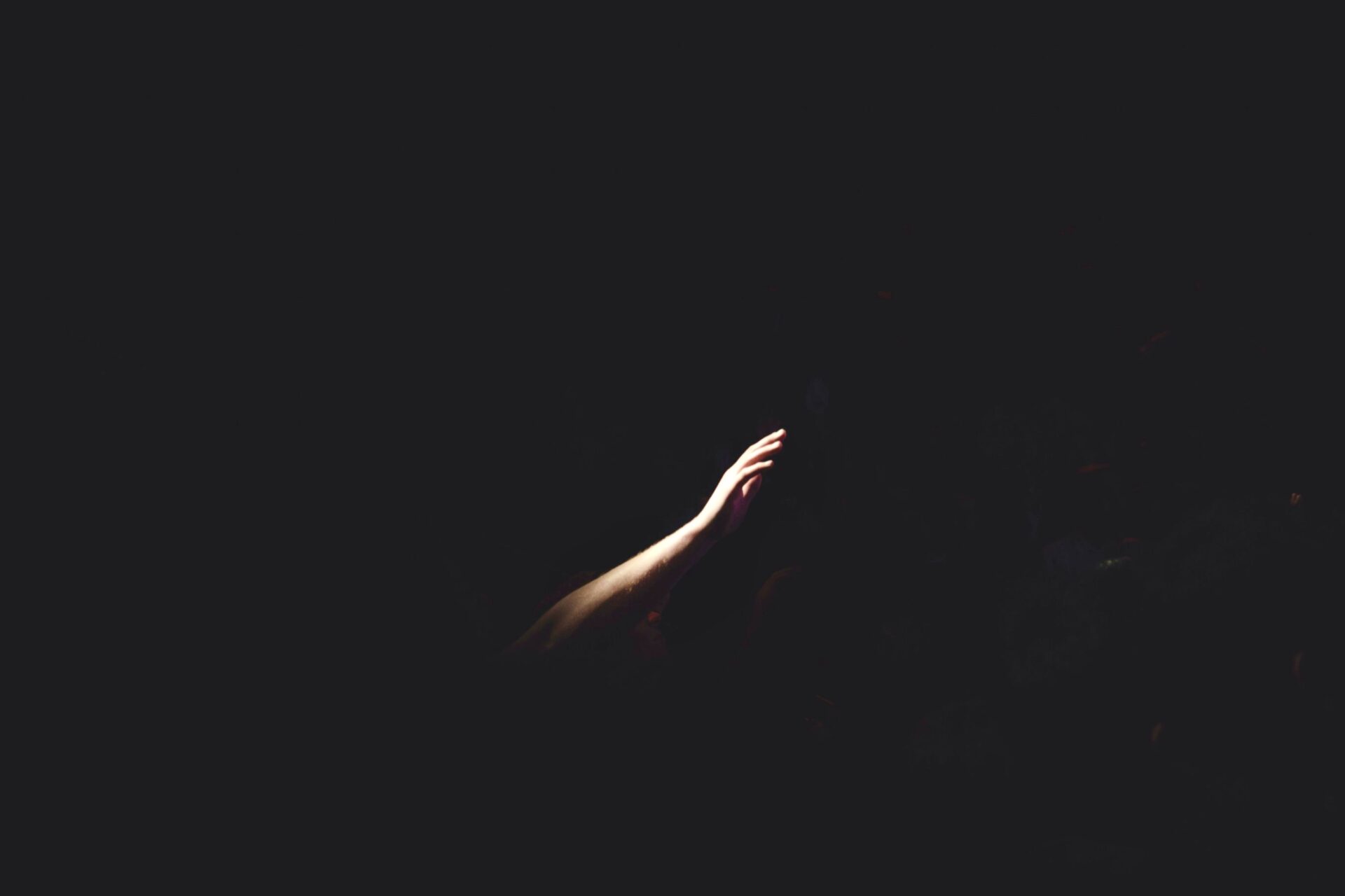 Hand reaching out from darkness